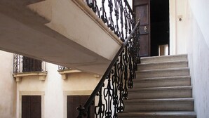 A staircase with ornate black metal railings and a wooden door at the top.