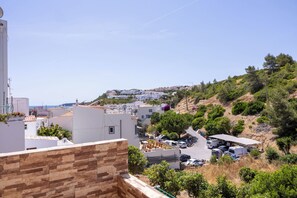 Zona residencial con edificios blancos, una calle pavimentada y áreas verdes.