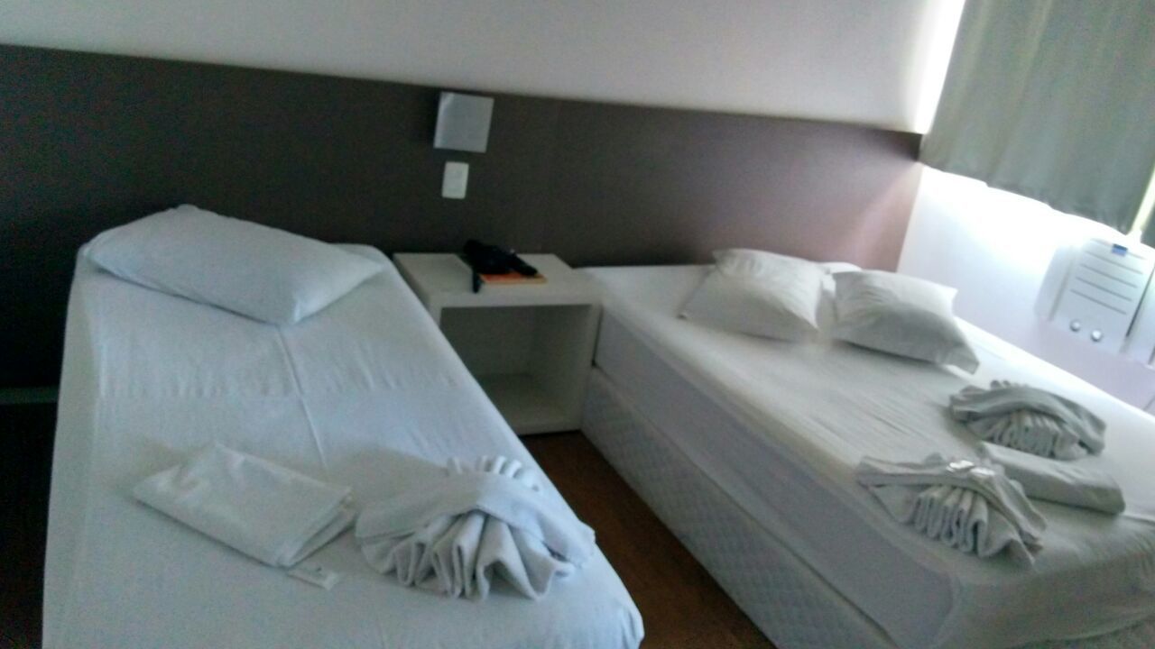 Una habitación de hotel con dos camas, una mesita de noche y un buró.