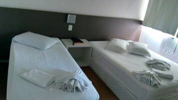 Una habitación de hotel con dos camas, una mesita de noche y un buró.