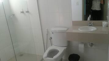 Un baño con inodoro, lavamanos y ducha.