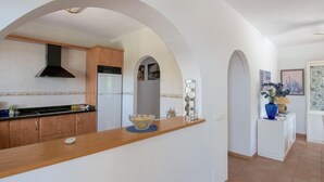 A modern kitchen with wooden cabinets, a black range hood, and a white refrigerator. - House with Private Pool (Herrera) (Arenas)