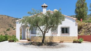 A white building with a tiled roof, a chimney, and a tree in front. - House with Private Pool (Herrera) (Arenas)