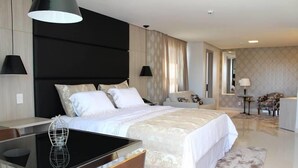 A modern hotel room with a large bed, a dining table, and a separate seating area. - Hotel Solaris (Formosa)