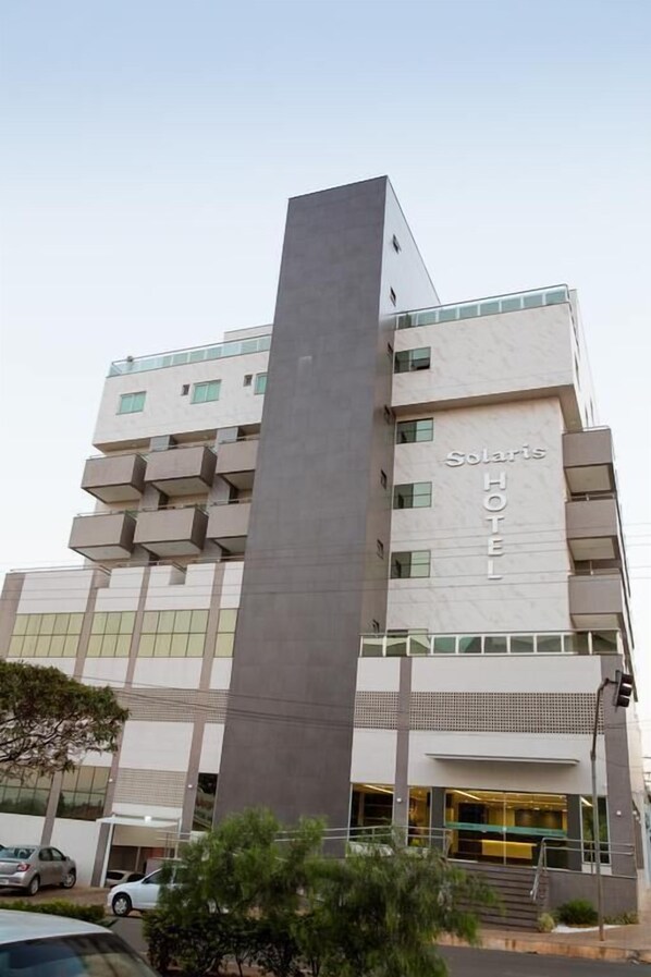 A modern hotel building with a prominent vertical structure and balconies.