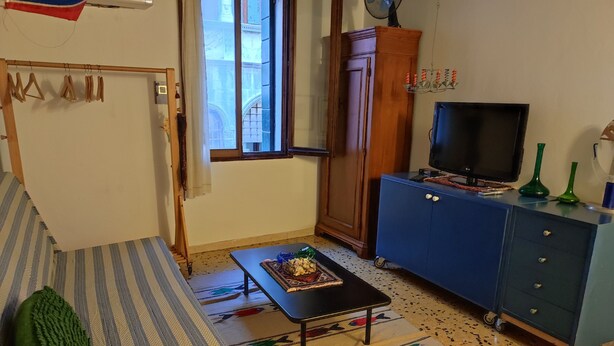A living room with a sofa, a coffee table, a TV, a cabinet, and a window. - apartment/ flat - Venezia (Venezia)