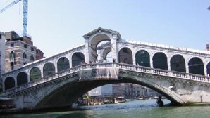 A stone bridge with arches over a body of water, with buildings and a construction crane in the background. - apartment/ flat - Venezia (Venezia)