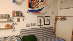A cozy room with a striped sofa, a small desk, and a bookshelf. - apartment/ flat - Venezia (Venezia)