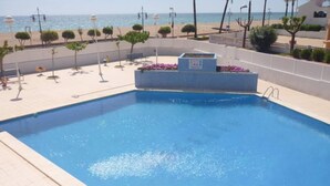 En swimmingpool med udsigt til strand og hav.