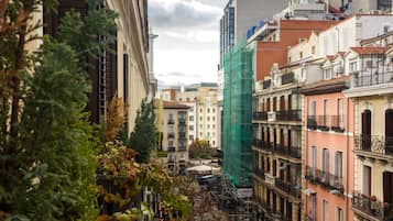 Una calle estrecha flanqueada por edificios, algunos con balcones y otros con comercios en la planta baja.