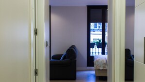 Un pasillo que conduce a una sala de estar con un sofá y una mesita.