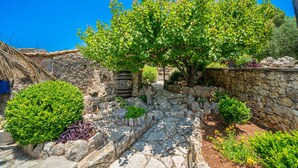 Un sendero de piedra que conduce a una edificación rústica con techo de paja.