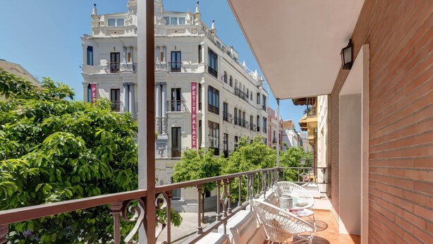 En balkon med udsigt til en bygning, hvor der står 