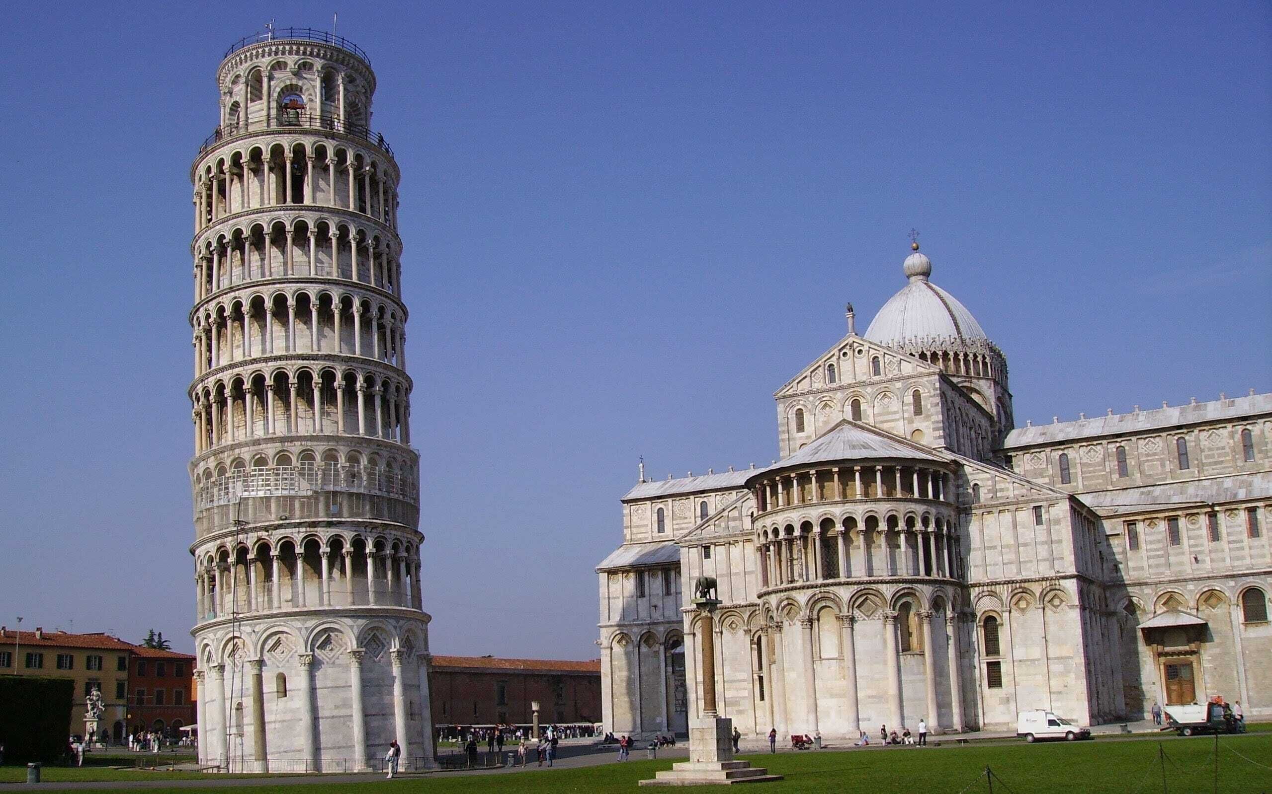 A historic tower with a spiral staircase and a large dome building with arched windows and columns.