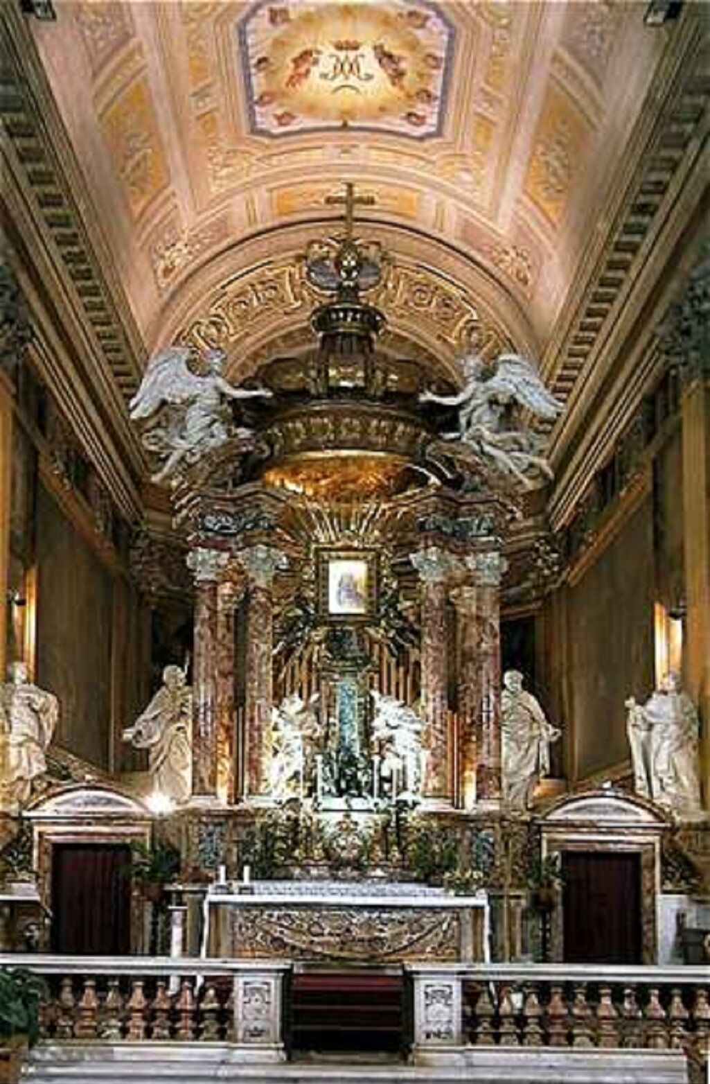 An ornate altar with statues and a chandelier in a church interior.