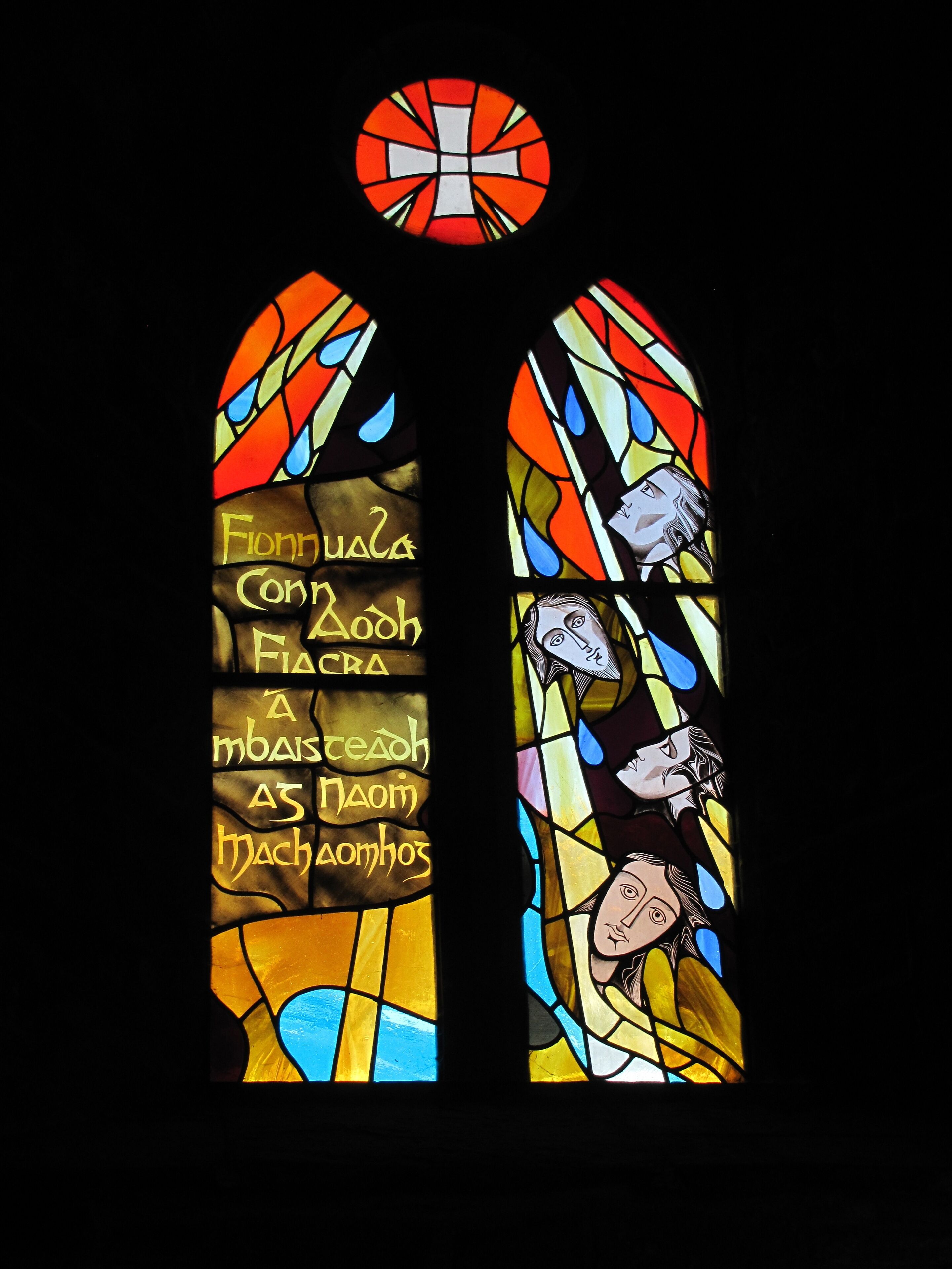 Une vitre décorative composée de vitraux aux motifs géométriques et aux inscriptions.
