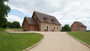 A large, two-story stone building with a gravel driveway leading to a wooden barn. - Quiet new house with character, private heated pool (Sergeac)