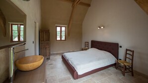 A bedroom with a large bed, a wooden chair, a wooden cabinet, and a large mirror. - Quiet new house with character, private heated pool (Sergeac)