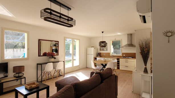 A modern living room with a TV, sofa, and dining area. - house / villa - 3 rooms - 6 persons (Pont-Saint-Esprit)