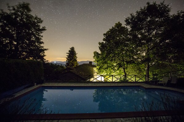 A swimming pool with a view of the night sky and trees. - Family friendly Tuscan Villa ,private Pool, garden, stunning lake & hill views . (Caprese Michelangelo)