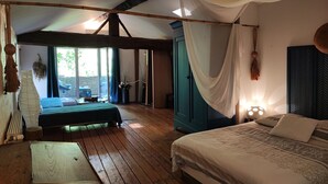 A bedroom with a bed, a wooden table, a wardrobe, and a view of the outdoors. - Mansion - Massillargues Attuech (Massillargues-Attuech)