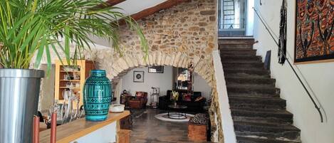 A stone archway leading to a living room with a staircase.