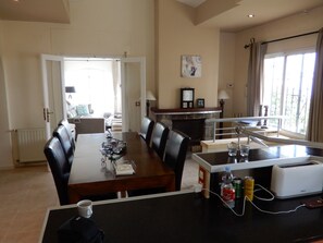Enjoy dining and socializing in this spacious room with a long table and comfortable seating.