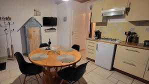 A compact kitchen with a dining area, a TV mounted above the counter, and a small refrigerator. - studio - ST PIERRE D OLERON (Saint-Pierre-D'oléron)
