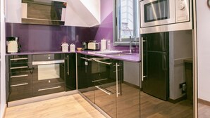 Een moderne keuken met een ingebouwde magnetron, oven en een groot raam.