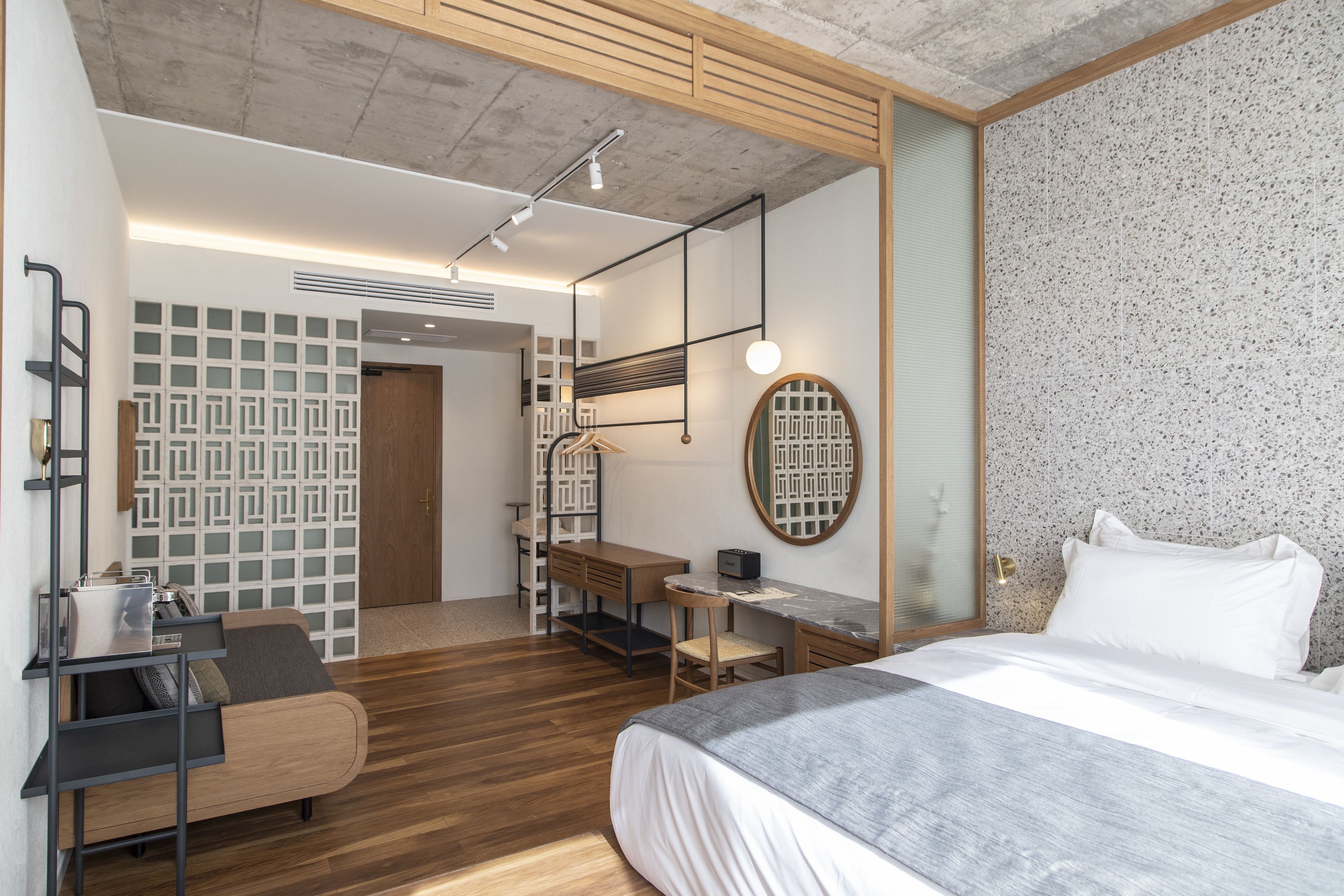 Un dormitorio moderno con cama, escritorio y zona de estar.