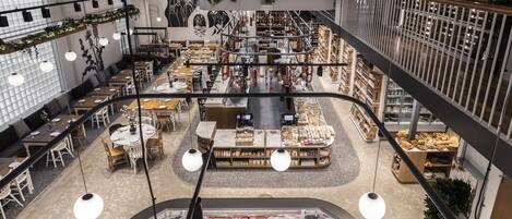 A multi-level shopping area with various food stalls, seating areas, and a central display of meat products.