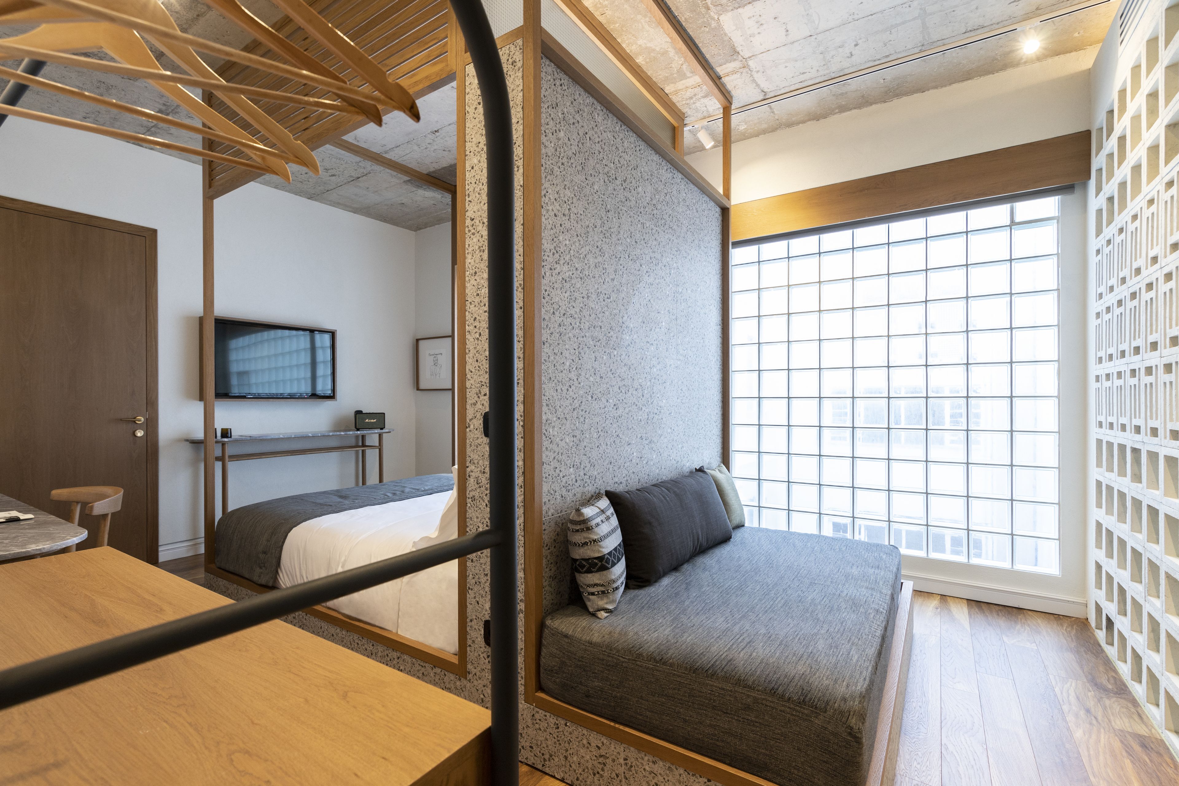 A modern room with a bed, a desk, and a large window.
