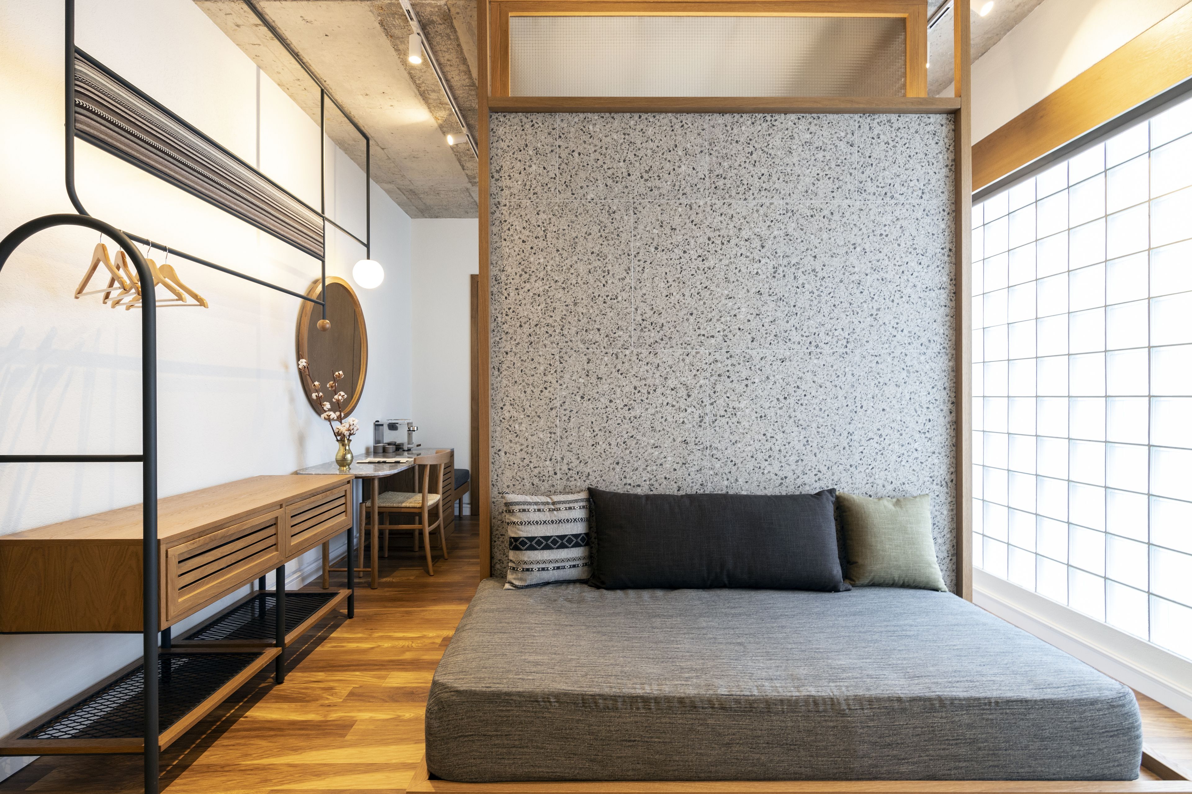 A bedroom with a bed, a desk, and a chair.