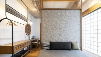A bedroom with a bed, a desk, and a chair.