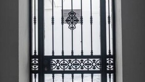 A black metal gate with decorative patterns.