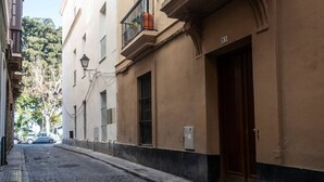 A narrow cobblestone street lined with buildings, featuring a building with a balcony and a door marked with the number 536.