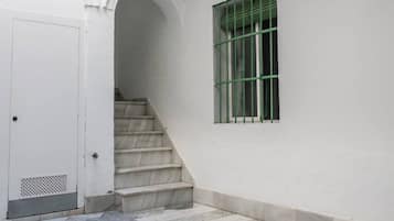 A staircase leading to a door with a barred window.