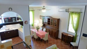 Un espace de vie compact comprenant une cuisine, un coin repas et un escalier.