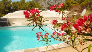 A pool with clear blue water, surrounded by white structures and red flowers. - Villa with wonderful panoramic sea view with private pool (Capri)