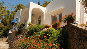 A white villa with arched windows and a stone wall. - Villa with wonderful panoramic sea view with private pool (Capri)