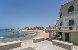 A coastal hotel with a balcony overlooking the beach, a clear sky, and a calm sea. - Deluxe Villa, just a stone's throw from Inspector Montalbano's beach (Punta Secca)