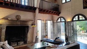 A spacious living area with a fireplace, a balcony, and large windows providing natural light. - Mansion - Port -vendres (Port-Vendres)
