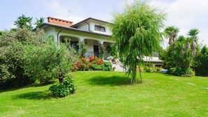 A two-story house with a garden in front. - La Bouganville swimming pool & relaxation (Camaiore)