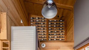 Une cuisine compacte avec des meubles en bois, un four à micro-ondes encastré et un meuble à bouteilles.