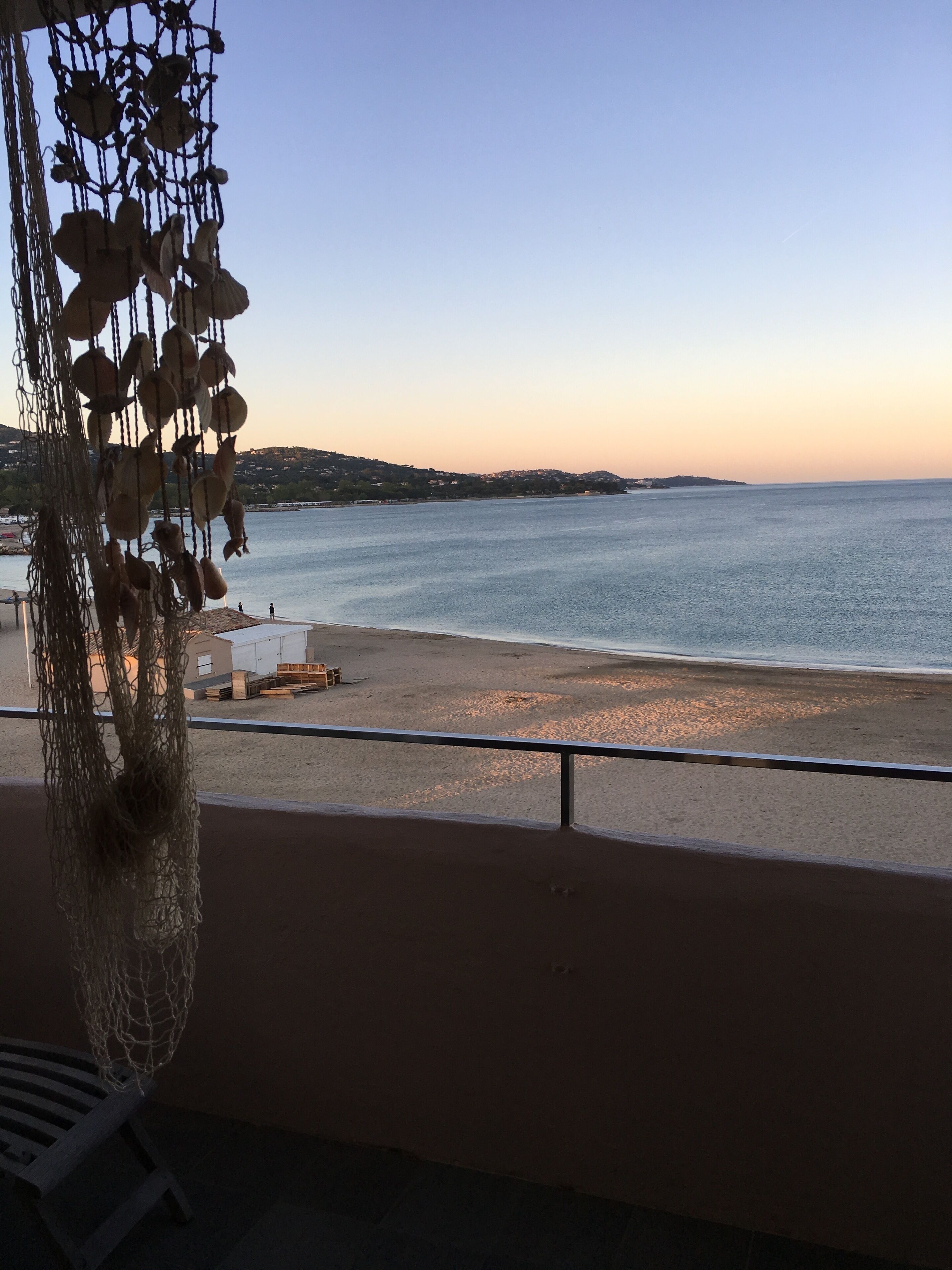 Ein Balkon mit Blick auf Strand und Meer.