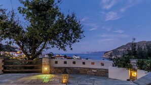 Eine Steinterrasse mit Pool, Liegestühlen und Laternen.