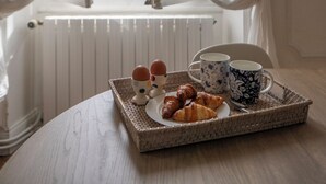 A breakfast tray with croissants and eggs on a table by a window with white curtains. - Elegant 7-Bedroom Château in Burgundy Wine Country Near Chablis & Auxerre (Hauterive)