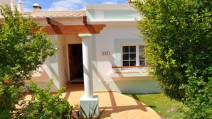 Une maison à deux étages avec un balcon, une porte et une fenêtre.