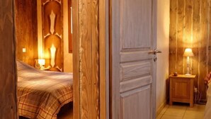 Una habitación con cama, paneles de madera y una mesita de noche con lámpara.