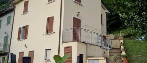 Een gebouw met twee verdiepingen, een balkon en een trap naar de bovenverdieping.